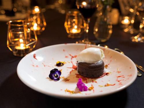 a white plate with a chocolate dessert on a table at Pullman Sydney Olympic Park in Sydney