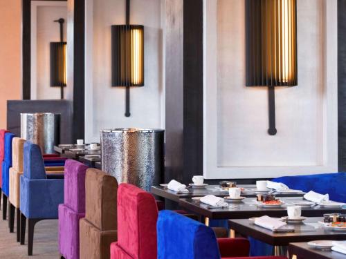 a dining room with tables and chairs and lights at Sofitel Casablanca Tour Blanche in Casablanca