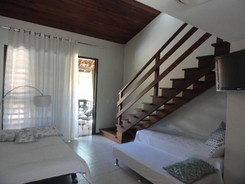 a living room with a staircase and a couch at Apartamentos La Piazzetta Duplex in Pipa