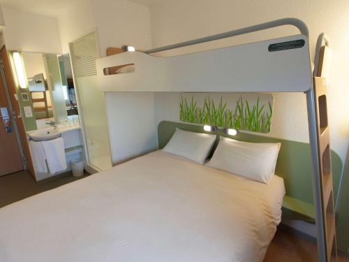 a bedroom with a bunk bed with white pillows at ibis budget Cherbourg - La Glacerie in Cherbourg en Cotentin