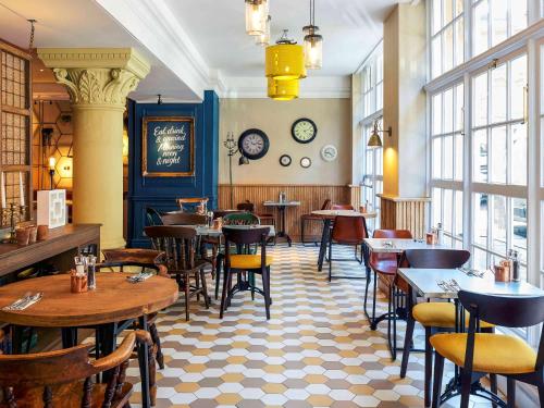 a restaurant with tables and chairs and windows at The Grand Bristol By Sunday in Bristol