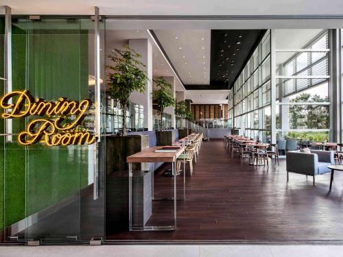 a dining room with tables and chairs in a building at Pullman Miri Waterfront in Miri