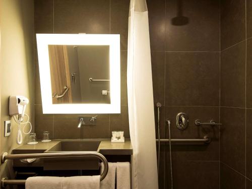 a bathroom with a sink and a mirror at Novotel Santos Gonzaga in Santos