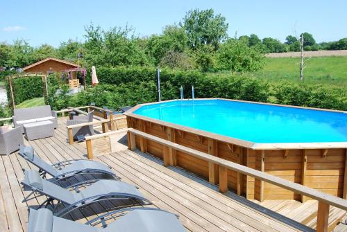 - une grande piscine sur une terrasse avec un bateau dans l'établissement Rustic and spacious converted Barn, à Isigny-le-Buat