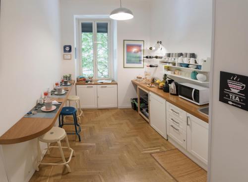 ナポリにあるThe Andy House B&Bの白いキャビネット付きのキッチン、カウンター(スツール付)