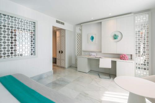 cocina blanca con mesa y comedor en Gran Hotel Miramar GL, en Málaga
