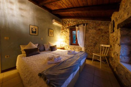 a bedroom with a bed and a chair in a room at Villa Melite in Agios Nikolaos