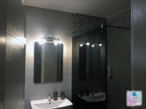 a bathroom with two sinks and a mirror at 3M Apartment Skopje Center in Skopje
