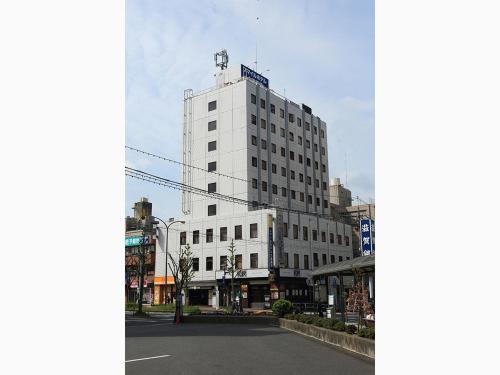 a white building with a blue sign on top of it at Smile Hotel Otsu Seta in Otsu
