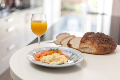 Golf Lodge Bed & Breakfast في نورث بيرويك: صحن من الطعام وكأس من عصير البرتقال والخبز
