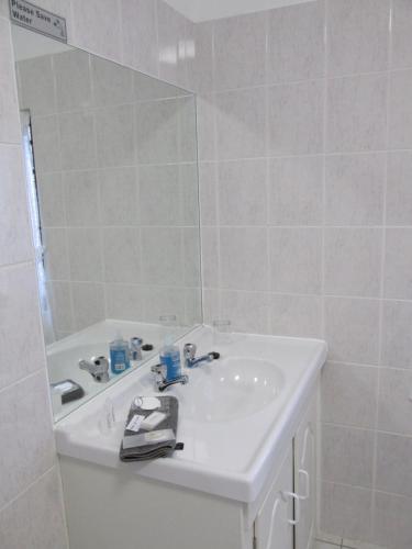 a white bathroom with a sink and a mirror at Casa Del Mar in Hermanus