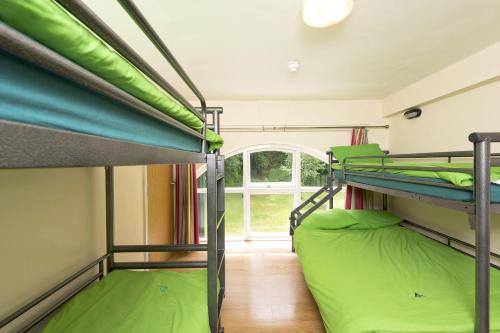 two bunk beds in a room with a window at YHA Okehampton - Partner in Okehampton