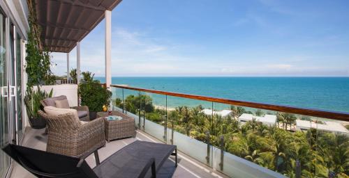 a balcony with chairs and a view of the ocean at The Cliff Resort & Residences in Mui Ne