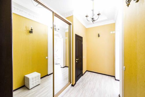 a mirror in a hallway with yellow walls at Adler in Astana