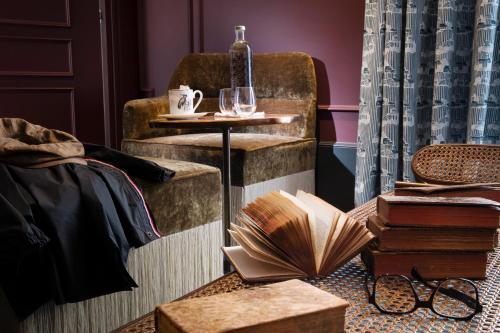 a room with a table with books and a chair at Hôtel Monte Cristo in Paris