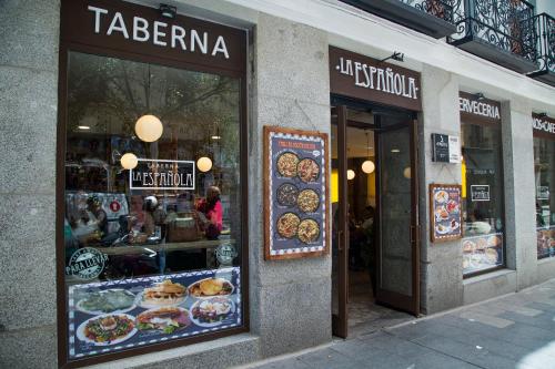 a store front of a bakery with signs in the window at JC Rooms Chueca in Madrid