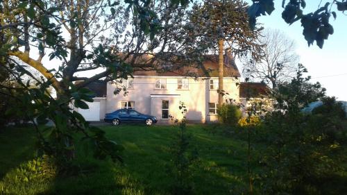 a blue car parked in front of a house at Lisieux House on Lough Neagh in Aghalee