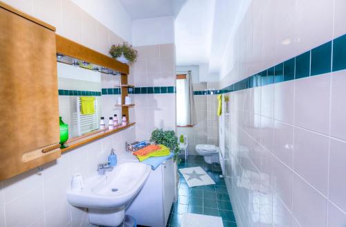 bagno bianco con 2 servizi igienici e lavandino di Rita's Garden a San Vittore Olona