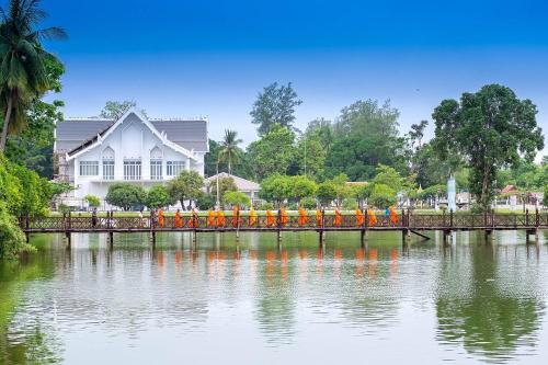 a bridge over a body of water with people on it at Phiphu Art and Gallery Boutique Sukhothai in Sukhothai