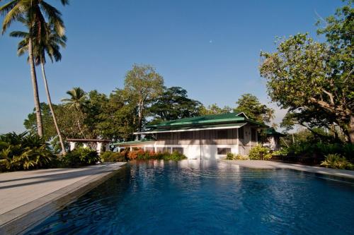 Tagum的住宿－伊霍達沃酒店，一座带游泳池的度假村,位于一座建筑前