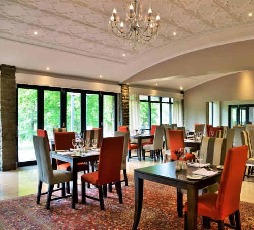 une salle à manger avec des tables et des chaises ainsi qu'un lustre dans l'établissement Premier Resort Sani Pass, à Himeville