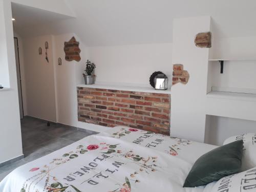 a bedroom with a bed with a brick fireplace at Statek u kapličky in Skalka