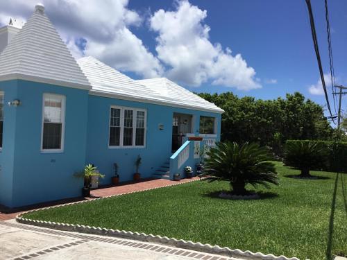 une maison bleue avec une pelouse devant elle dans l'établissement 7 Arches, à Hill View