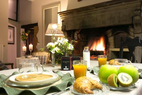 a table with bread and juice and a fireplace at San Michele al Borgo in Castiglion Fiorentino