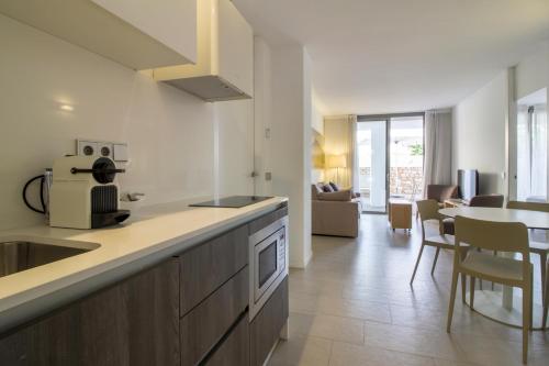 a kitchen with a sink and a table in a room at Apartaments B-Llobet Sun & Confort in Ibiza Town