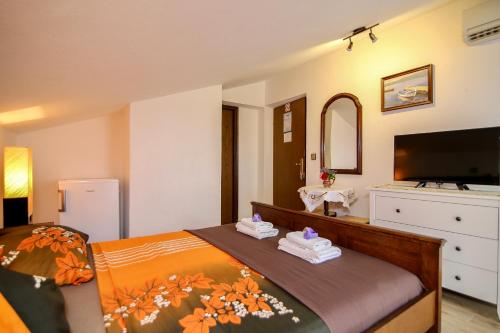 a bedroom with a bed with towels on it at Pansion Adria in Sveti Filip i Jakov
