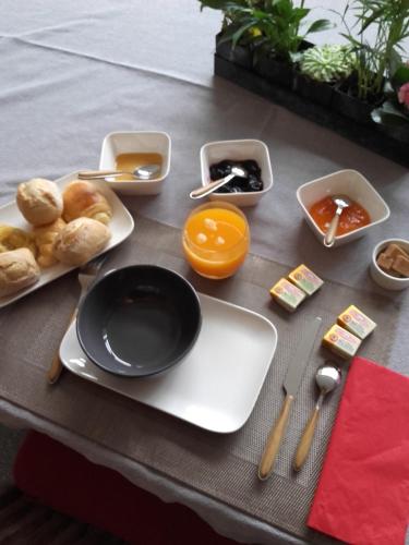 een tafel met borden en kommen met eten erop bij Chambre d'Hôtes Les Ecuries in Le Mans
