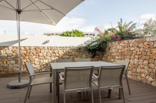 a table and chairs on a patio with an umbrella at Apartaments B-Llobet Sun & Confort in Ibiza Town