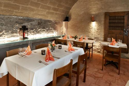a restaurant with white tables and chairs and a wall at Gasthof Bären in Ranflüh