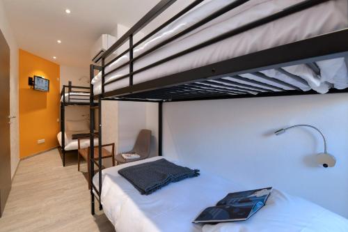 une chambre avec deux lits superposés et un bureau dans l'établissement Les Suites Du Cygne, à Colmar
