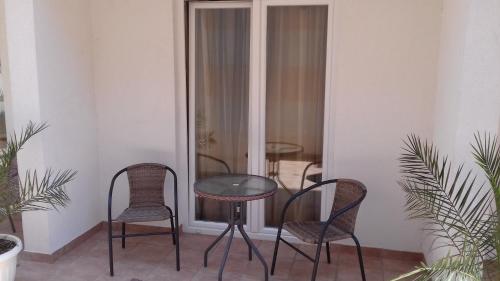 une table et des chaises dans une pièce ornée de plantes dans l'établissement Guest House Babić, à Neum