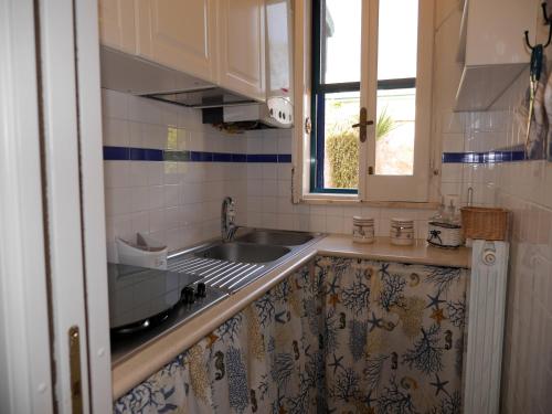 a kitchen with a sink and a window at Pietra di Luna a...mare in Polignano a Mare