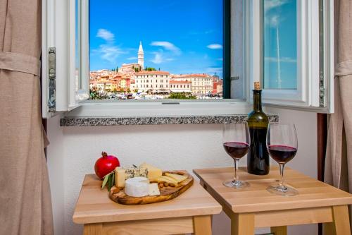 a table with two glasses of wine and a window at Perla Adriatica in Rovinj