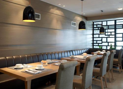 a dining room with wooden tables and chairs at Anatolia Hotel Komotini in Komotini
