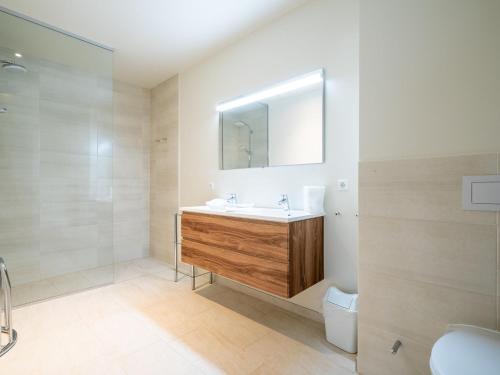 uma casa de banho com um lavatório, um espelho e um WC. em Warm Apartment in Gosau with shared Sauna em Gosau