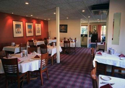 
a restaurant with tables, chairs, and tables in it at Citrus Valley Motel in Renmark
