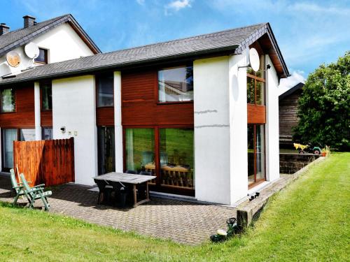 una casa con una mesa de picnic delante de ella en Comfortable Holiday Home in St Vith, en Amelscheid