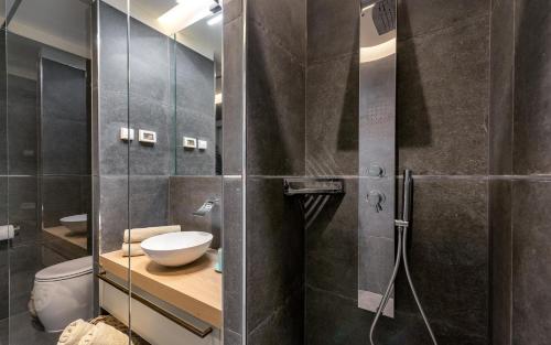 a bathroom with a shower with a toilet and a sink at Relais and Wine San Tommaso in Bale