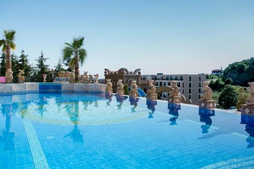 a large swimming pool with palm trees in the background at Villas Elenite Premium in Elenite