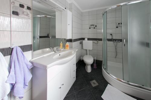 a bathroom with a sink and a toilet and a shower at Rooms Ivan in Otočac