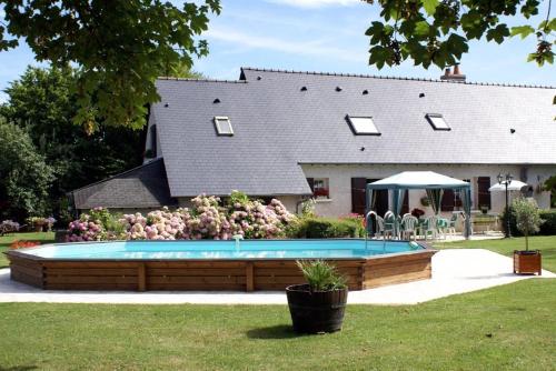 een huis met een zwembad in de tuin bij Villa Garnier in Saint-Michel-sur-Loire