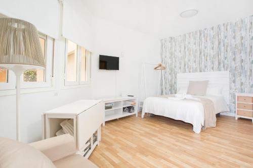 マラガにあるSuncity Studio Peñaの白いベッドルーム(ベッド2台、デスク付)