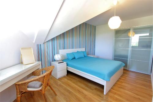 ダルウフコにあるBaltic Korona Apartamenty - E17のベッドルーム(青いベッド1台、椅子付)