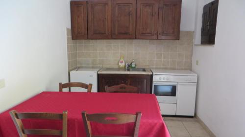 a kitchen with a table with a red table cloth at Fattoria Armonia in Stilo