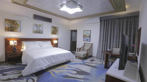 a bedroom with a bed and a television in it at Niyaf Serviced Apartments in Khamis Mushayt