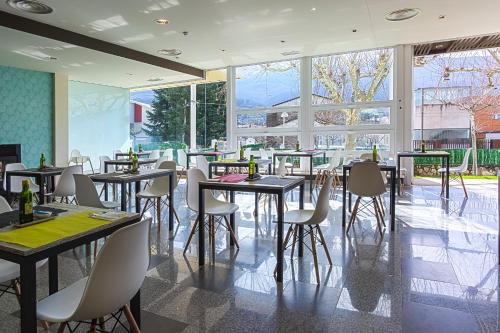 a restaurant with tables and chairs and a large window at Hotel Spa Sinagoga in Hervás